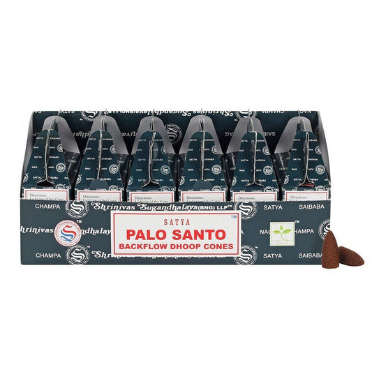 Box of Palo Santo backflow incense cones beside a stack of circular dhoop cones on a rustic surface.