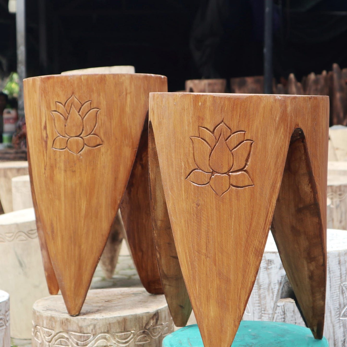 Two natural wood interlocking tables or stools with a unique curved design and smooth finish.