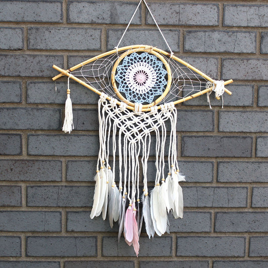 Medium macrame dream catcher with a blue and white evil eye motif, woven thread, and decorative tassels.