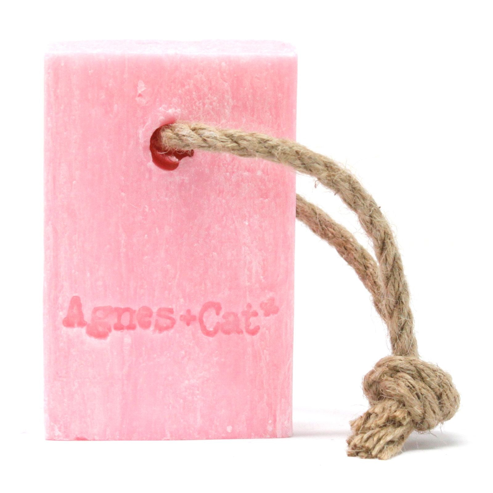 Artisanal pink soap bar with a natural hanging rope, featuring delicate floral textures and a fresh aesthetic.