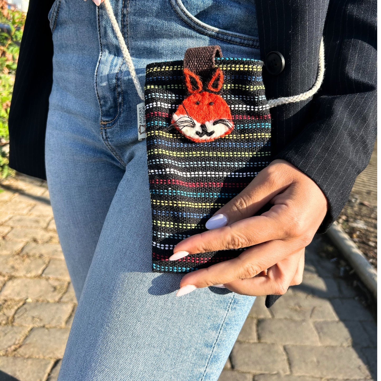 Handmade black fabric phone holder bag featuring a colourful embroidered fox design and a long shoulder strap.