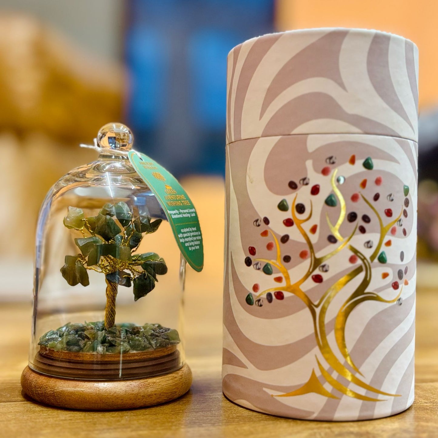 Handcrafted Green Aventurine gemstone tree with small green chipstones enclosed in a clear glass dome on a wooden base.
