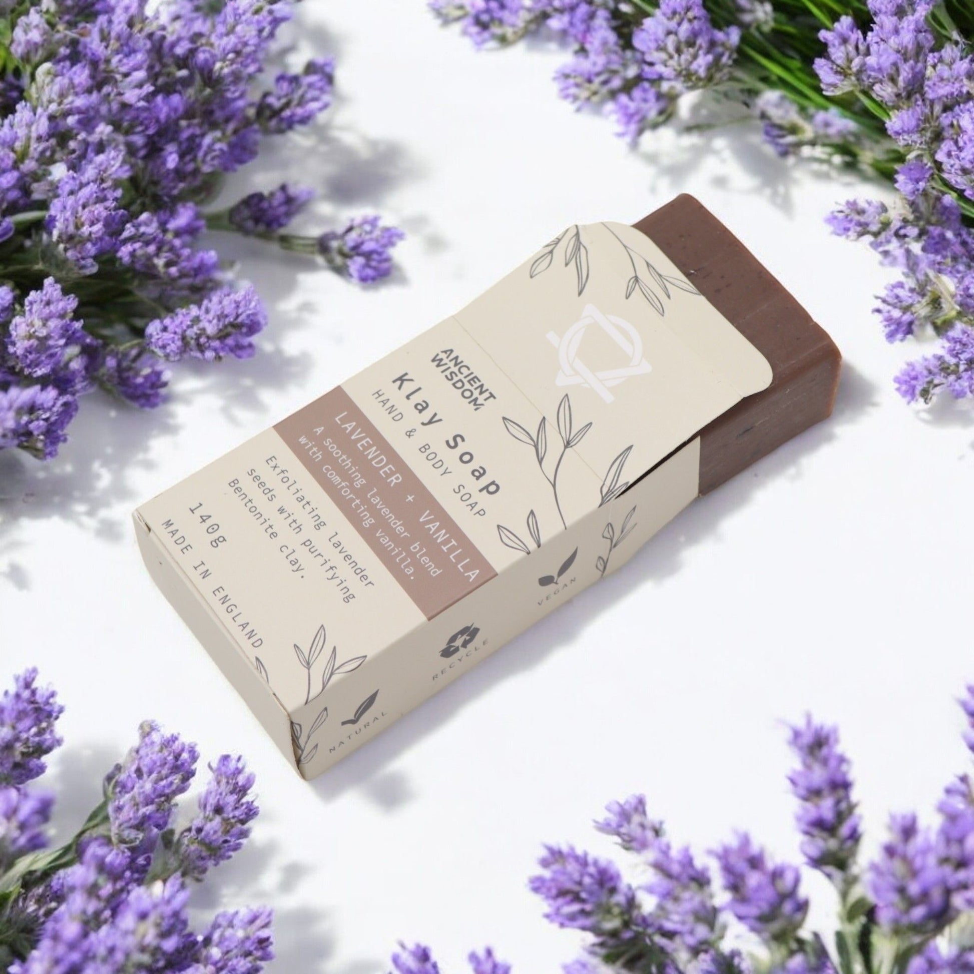 Artisan purple and cream layered soap bar topped with dried lavender seeds on a neutral background.