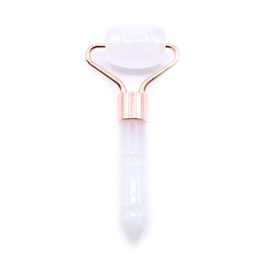 Small clear rock quartz gemstone face roller with a silver-toned metal frame and a smooth polished crystal head.