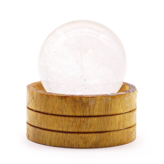 A polished 50mm clear quartz crystal sphere resting on a minimalist wooden display stand.