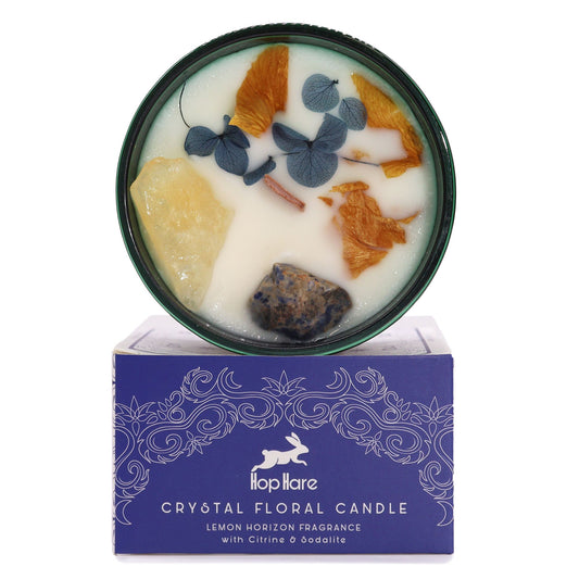 Yellow soy wax candle topped with dried flowers, Citrine, and Sodalite gemstones in a glass jar with a tarot card.