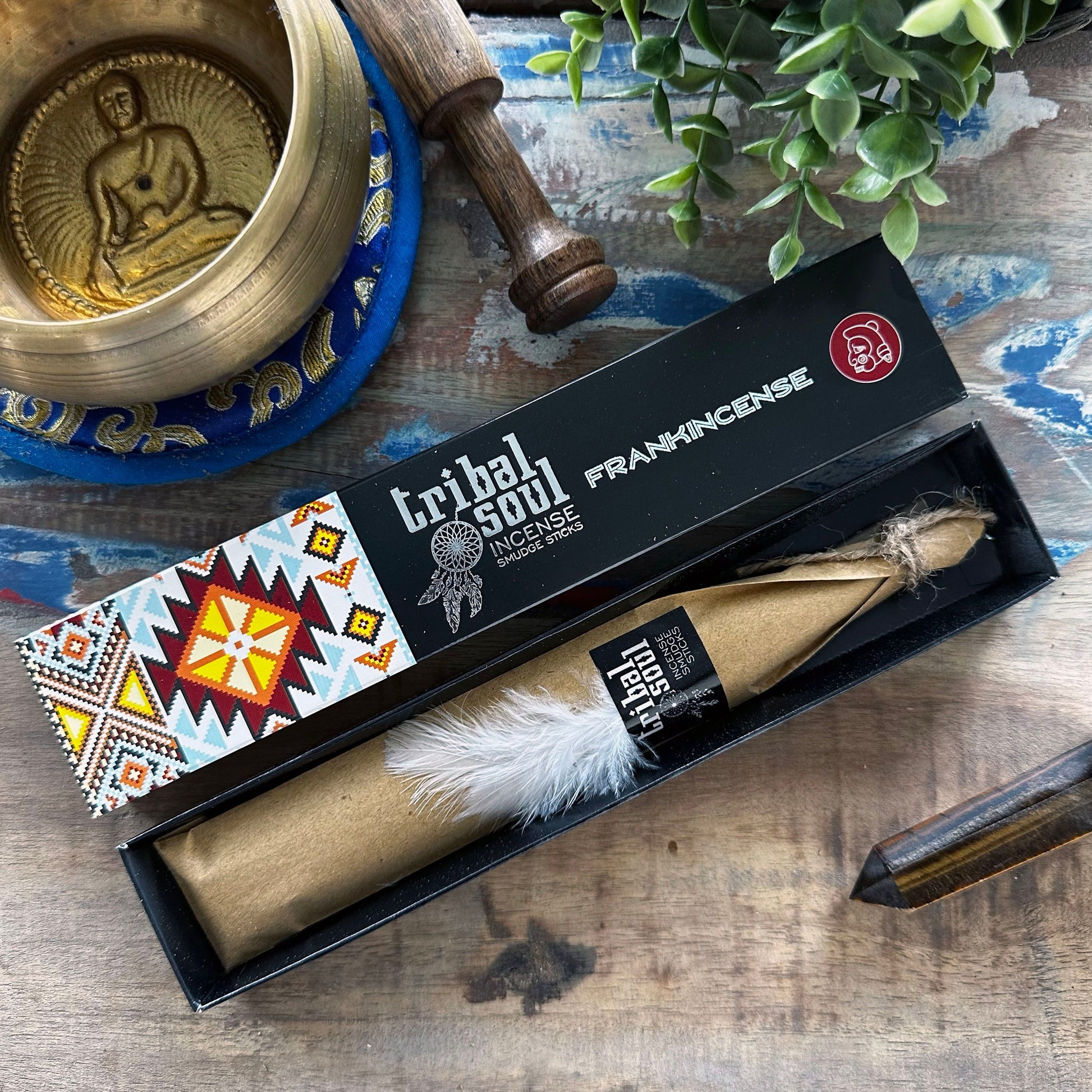 Hand-rolled incense sticks in a decorative box featuring traditional artwork and a single smouldering stick.