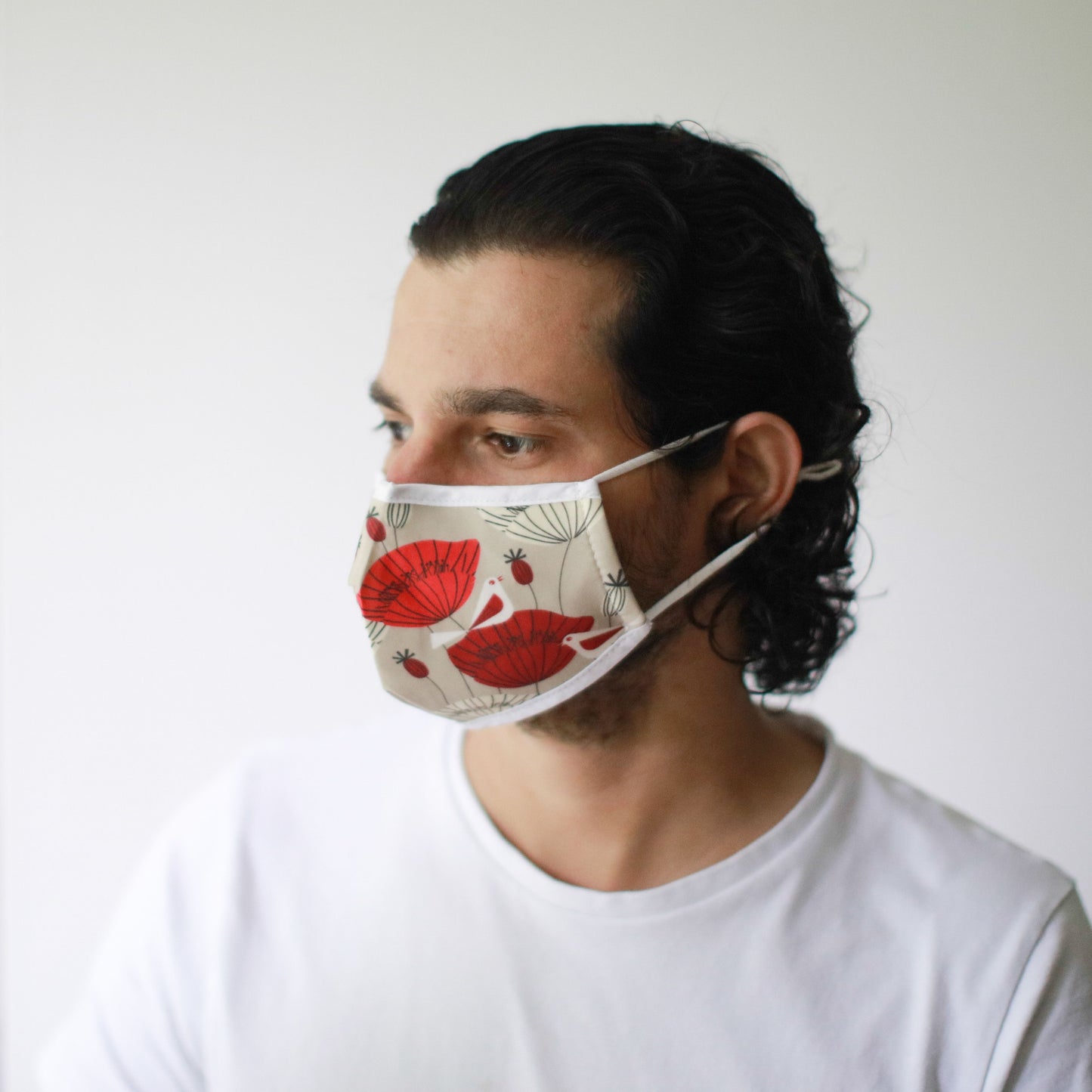 Adult-sized fabric face mask featuring a vibrant red and black oriental poppy floral pattern on a dark background.