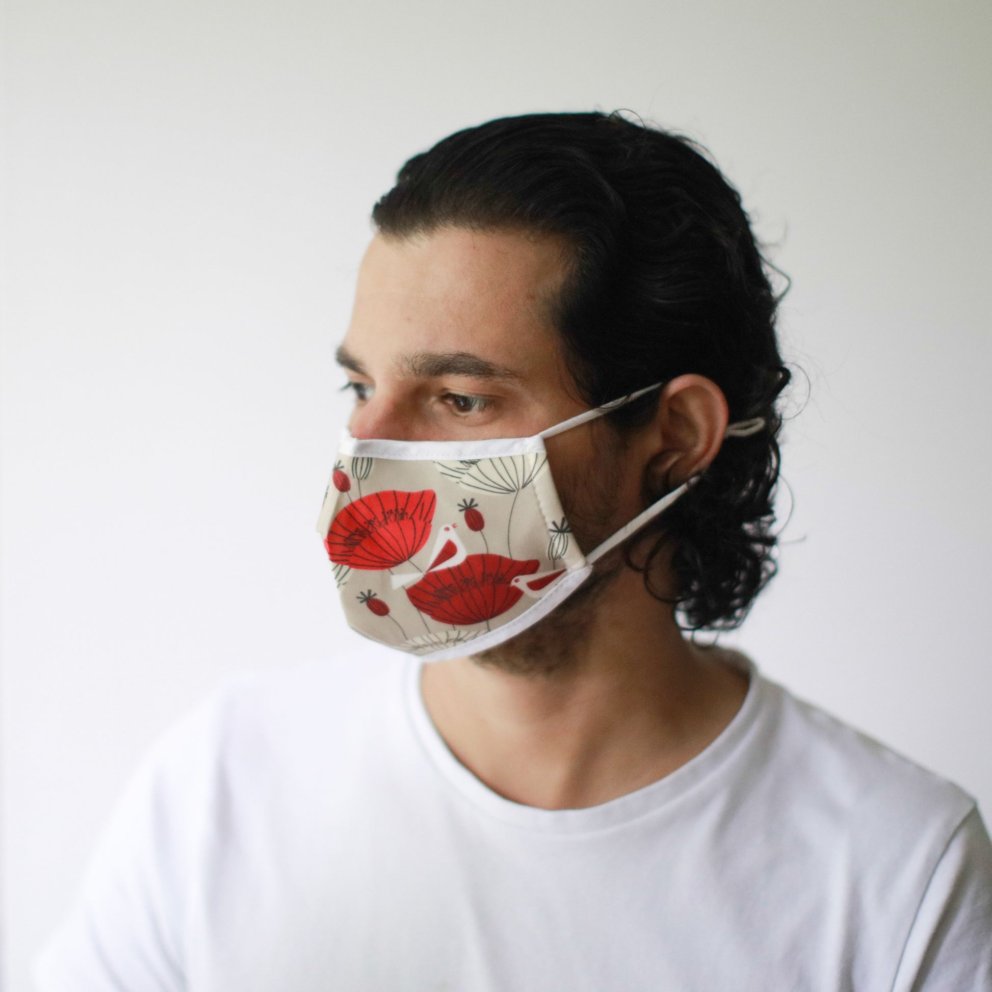 Adult-sized fabric face mask featuring a vibrant red and black oriental poppy floral pattern on a dark background.