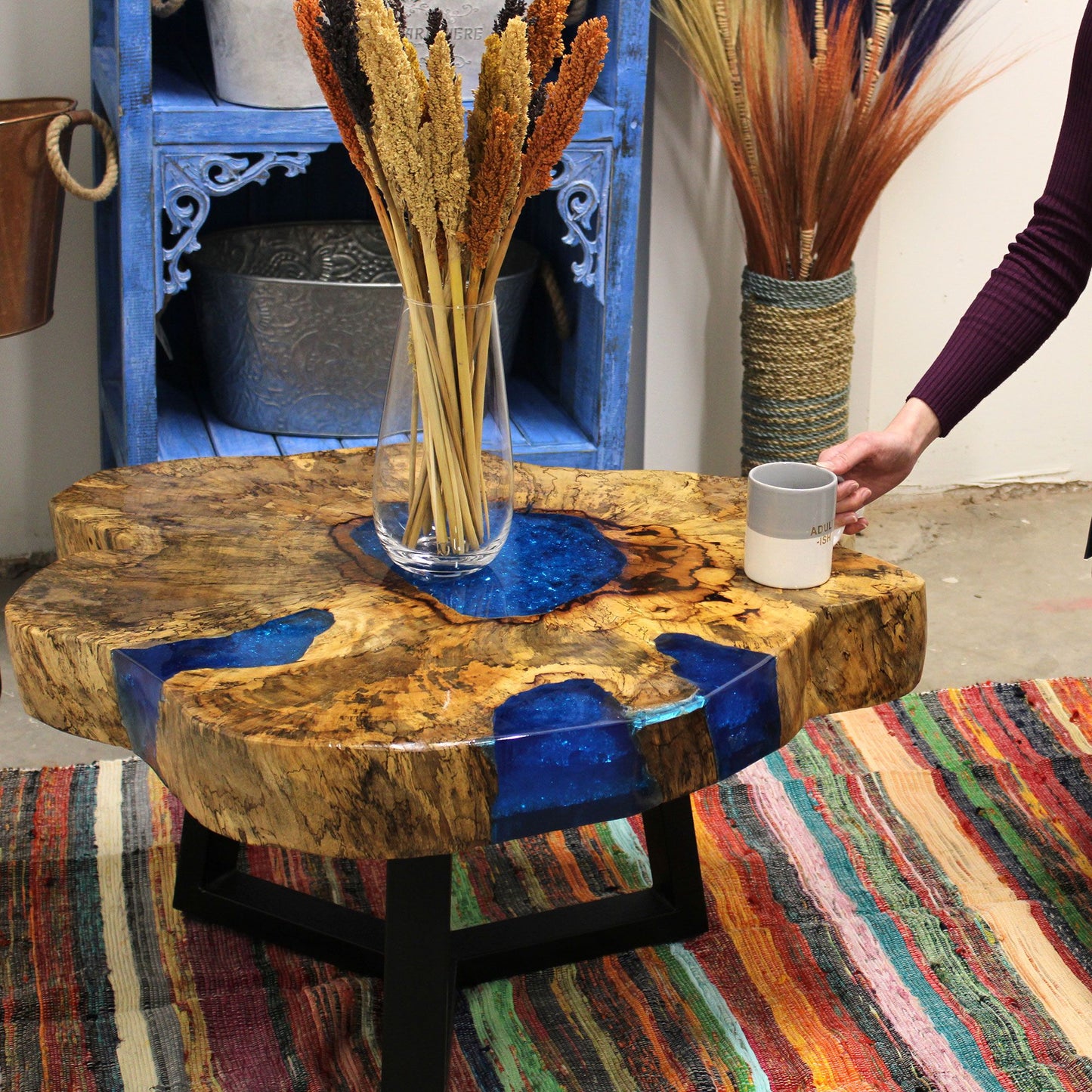 Round tamarind wood coffee table featuring a vibrant sky blue resin inlay and natural wood grain textures.