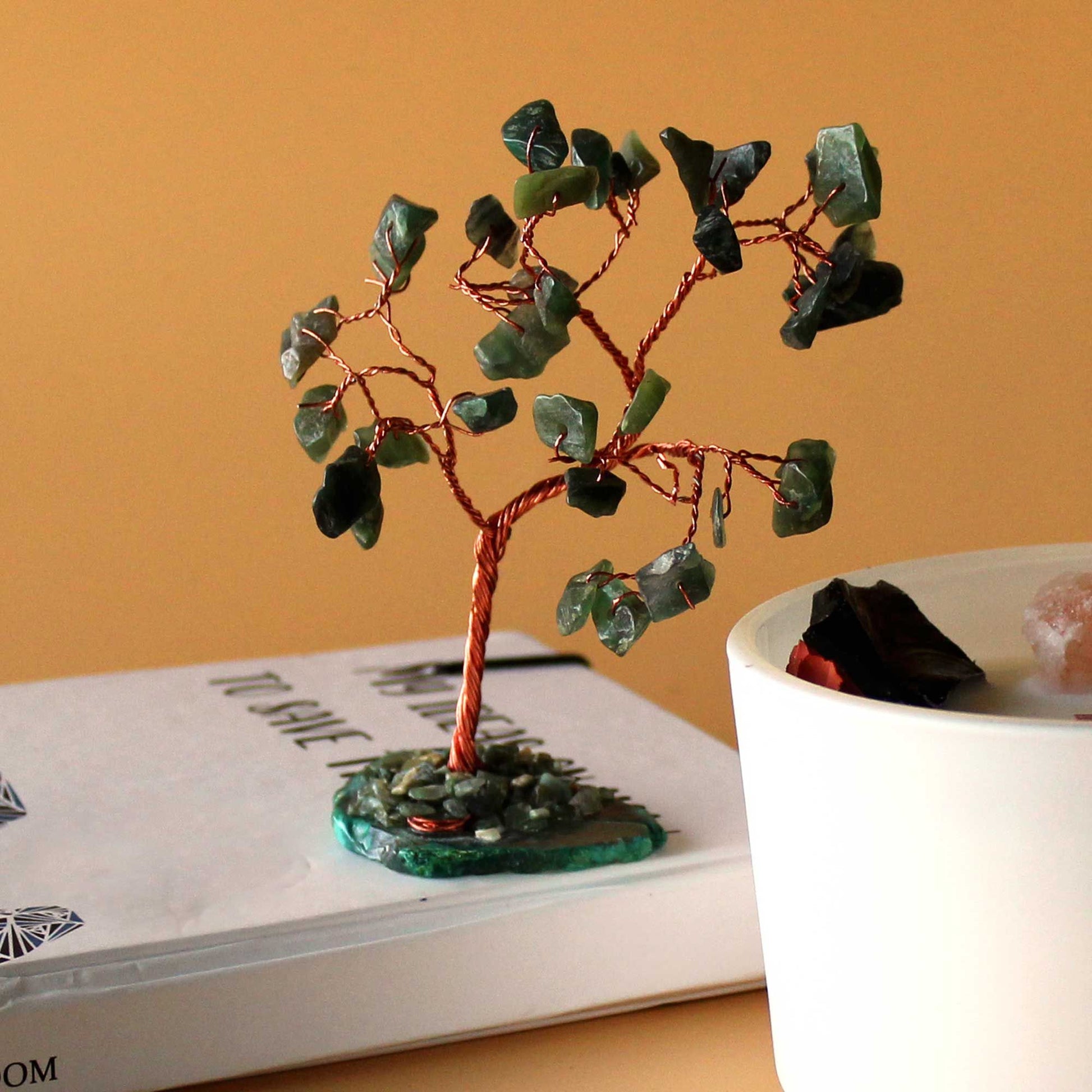 Handcrafted gemstone tree featuring green aventurine crystal leaves on a polished green agate slice base.