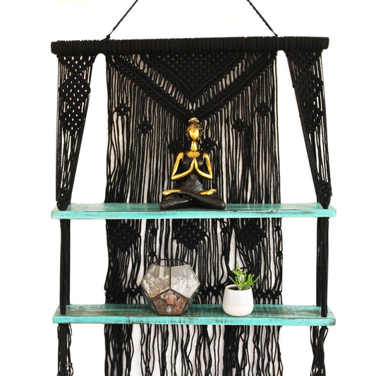Handmade black macrame hanging shelf featuring turquoise bead details and a natural wooden platform for small home decor.