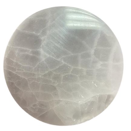 Smooth, circular white selenite charging plate with a minimalist plain finish on a neutral background.