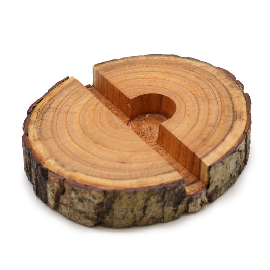 Rustic natural wood log slice with a pre-cut slot to hold a mobile phone on a flat surface.