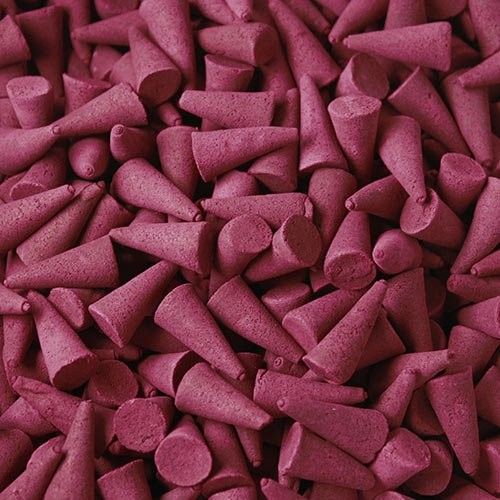 A large pile of vibrant red strawberry scented incense cones ready for use in home fragrance.