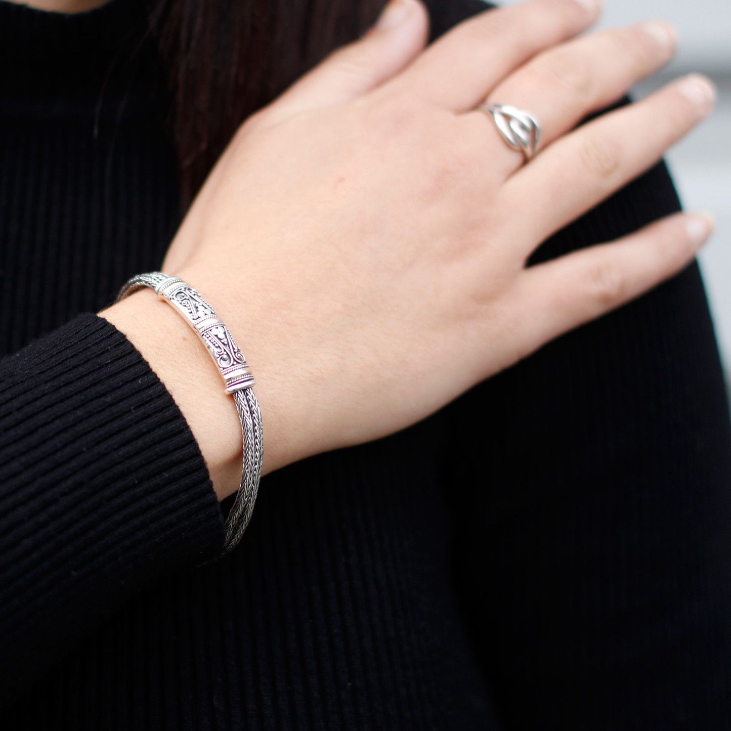 Detailed view of a unisex twin chain bracelet featuring interwoven silver and gold links in a modern style.