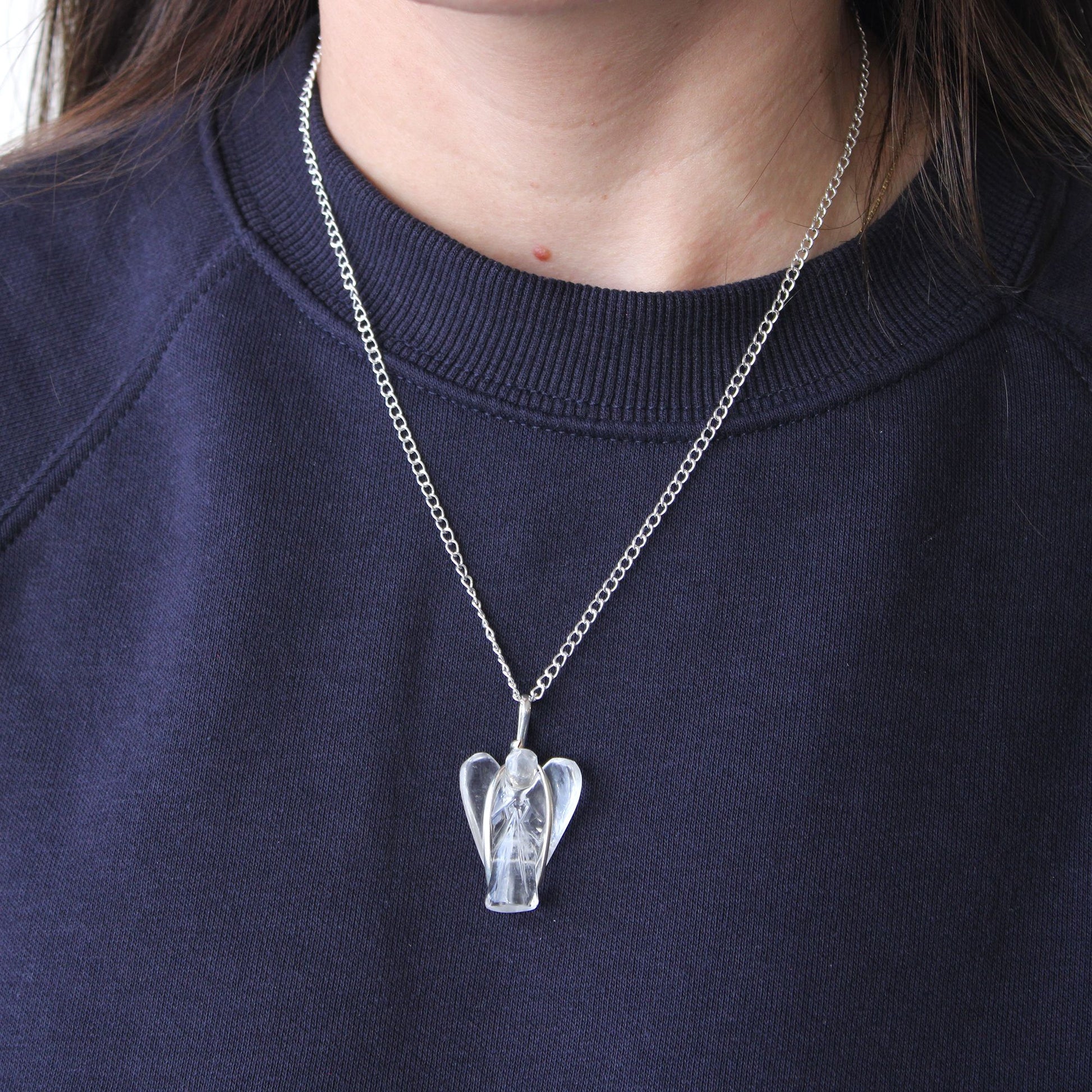 Delicately carved clear rock quartz gemstone in the shape of a guardian angel with a silver-tone bale.