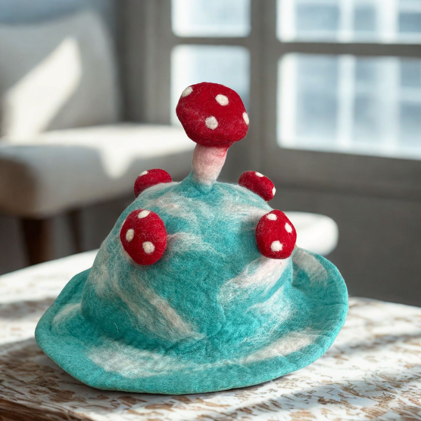 Handcrafted felted mushroom hat in a vibrant sky blue colour with white spots and a whimsical pointed top.