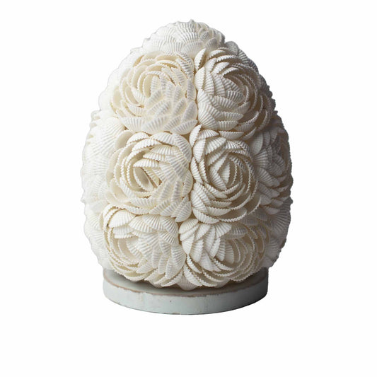 Handcrafted oval lamp made of delicate rose-tinted real seashells arranged in a decorative pattern on a white base.
