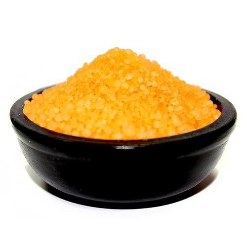 Small aromatic yellow simmering granules with a textured salt-like appearance for home fragrance.