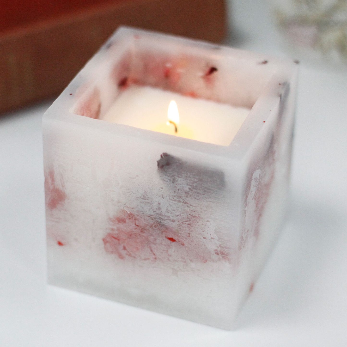 Large square rose scented candle with an enchanted glowing effect and floral details.