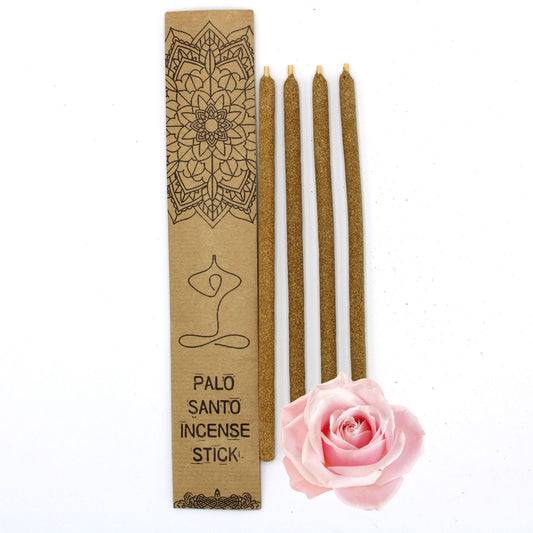 Large hand-rolled Palo Santo incense sticks infused with rose petals, resting on a wooden surface.