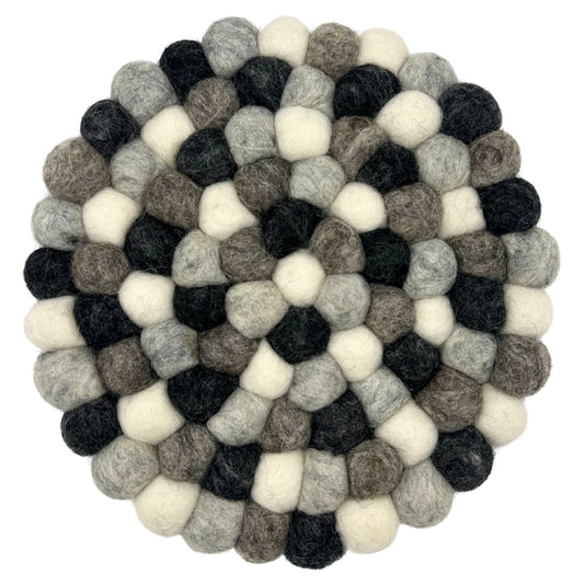 Round handmade placemat created from small felted wool balls in various shades of grey, arranged in a circular pattern.
