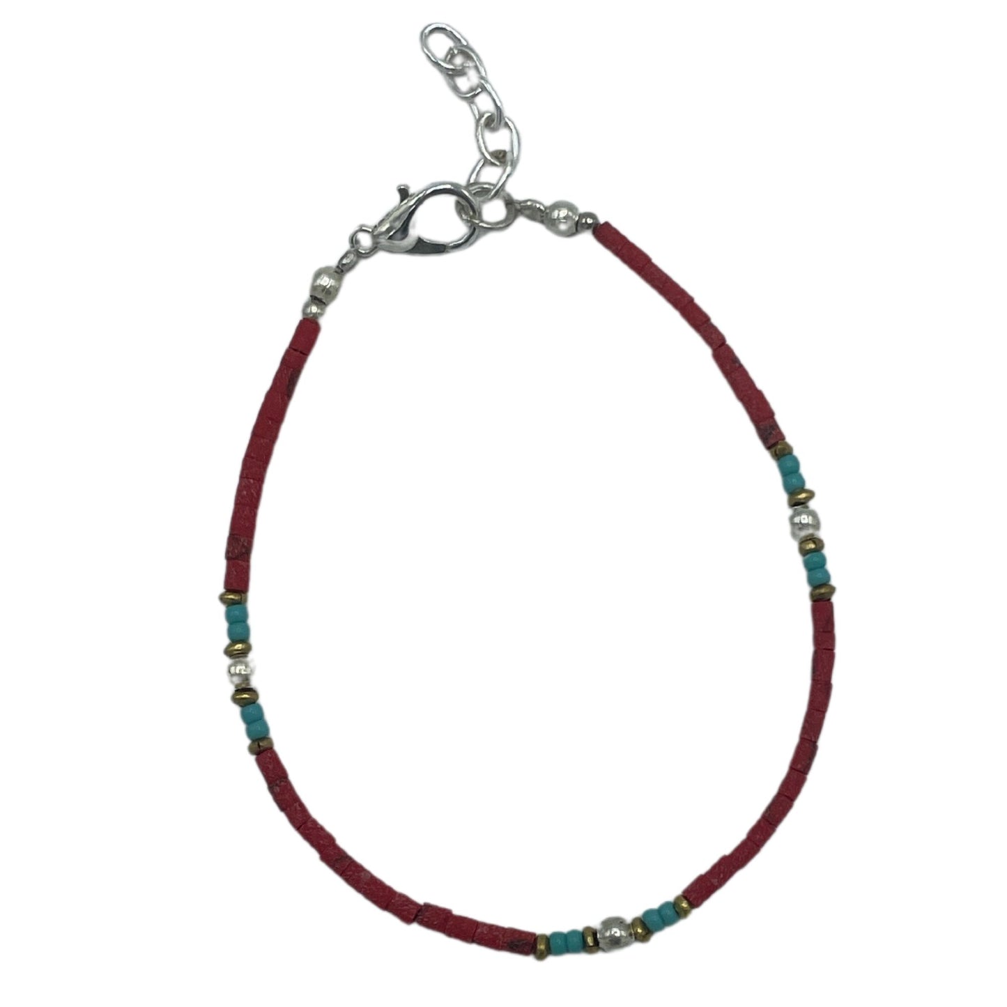 Handcrafted Nepalese bracelet featuring vibrant red coral beads and intricate silver-toned tribal accents.