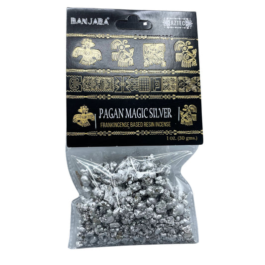 Close up of handcrafted aromatic tree resin pieces with a silver-toned mystical theme in a small bowl.