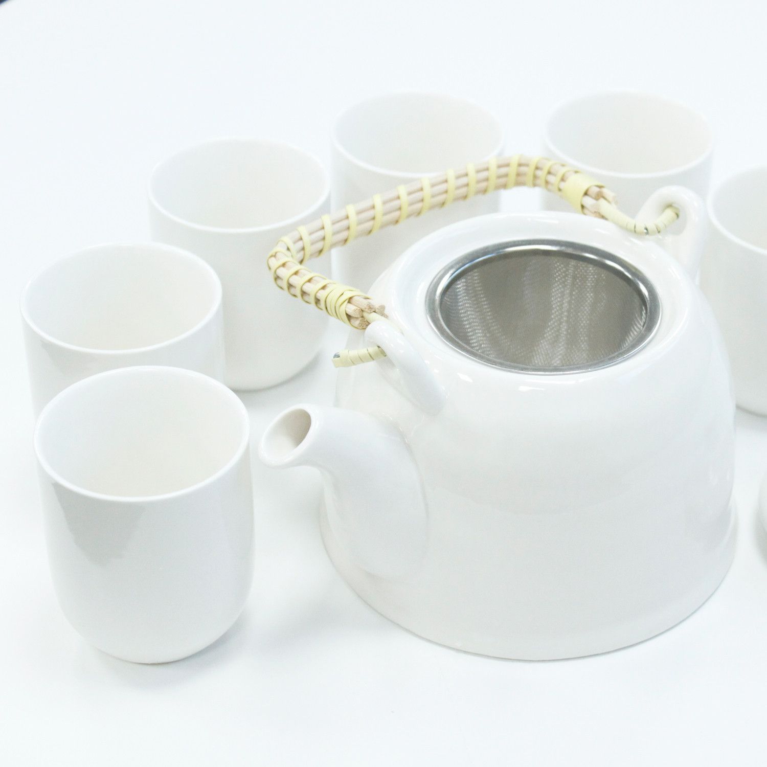 Elegant classic white ceramic teapot with a metal strainer lid and six matching small tea cups in a gift box.
