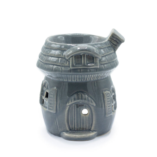 Whimsical grey ceramic oil burner shaped like a mushroom house with small window cut-outs.