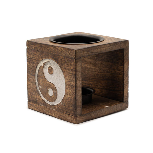 Square dark mango wood oil burner with a hand-carved Yin Yang symbol on the front and a ceramic dish on top.