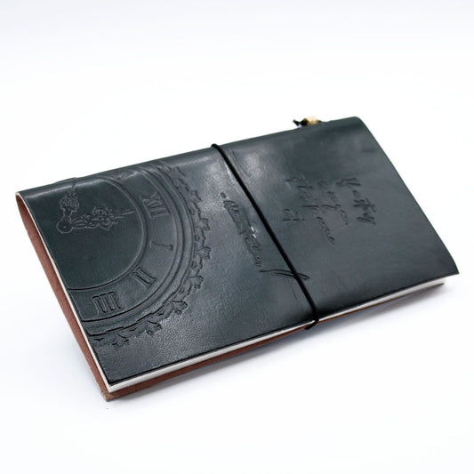 Slim green leather journal with an embossed quote and wrap-around band, featuring blank eco-friendly pages.