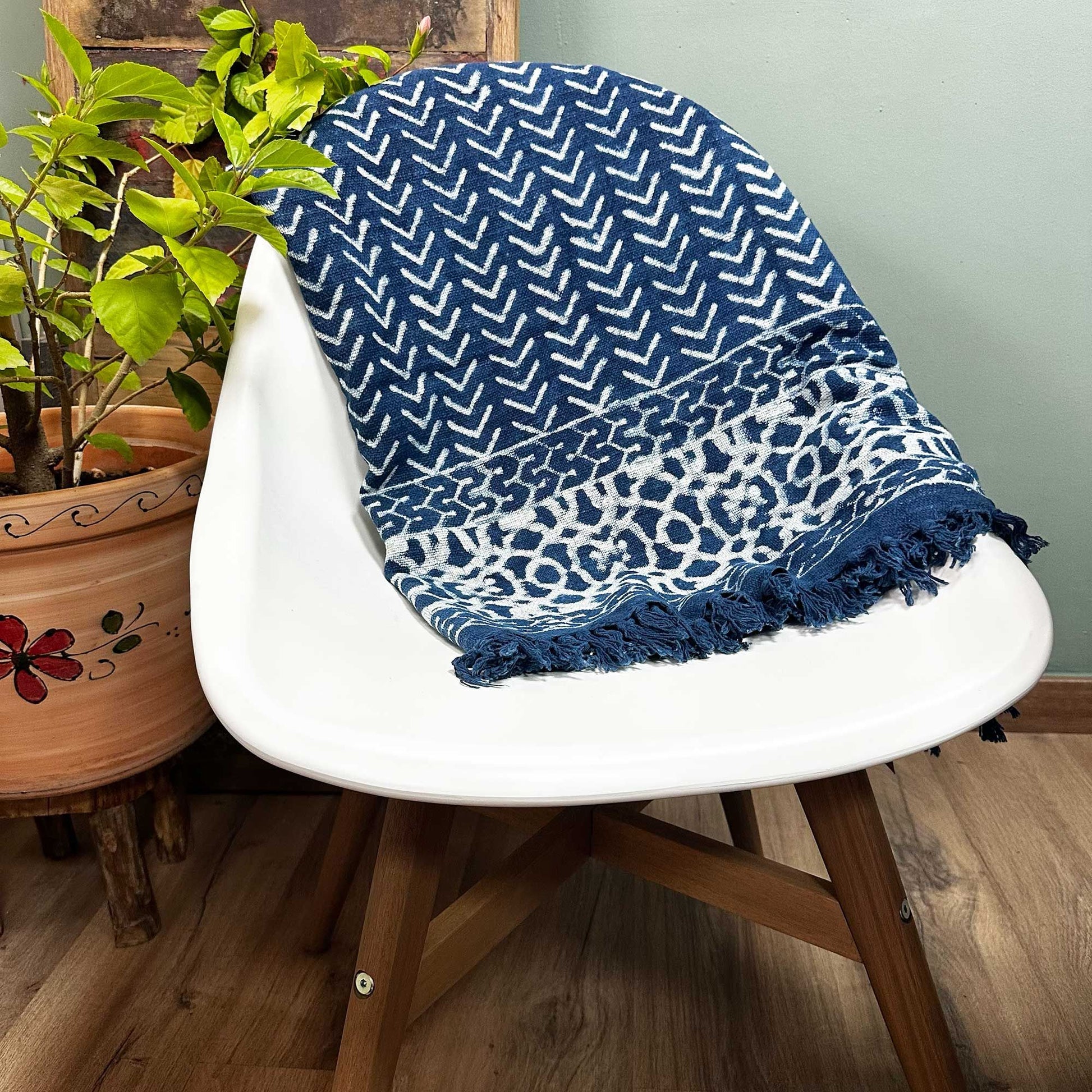 Close-up of a handmade indigo blue cotton throw featuring a white Seedha Arrows geometric pattern.