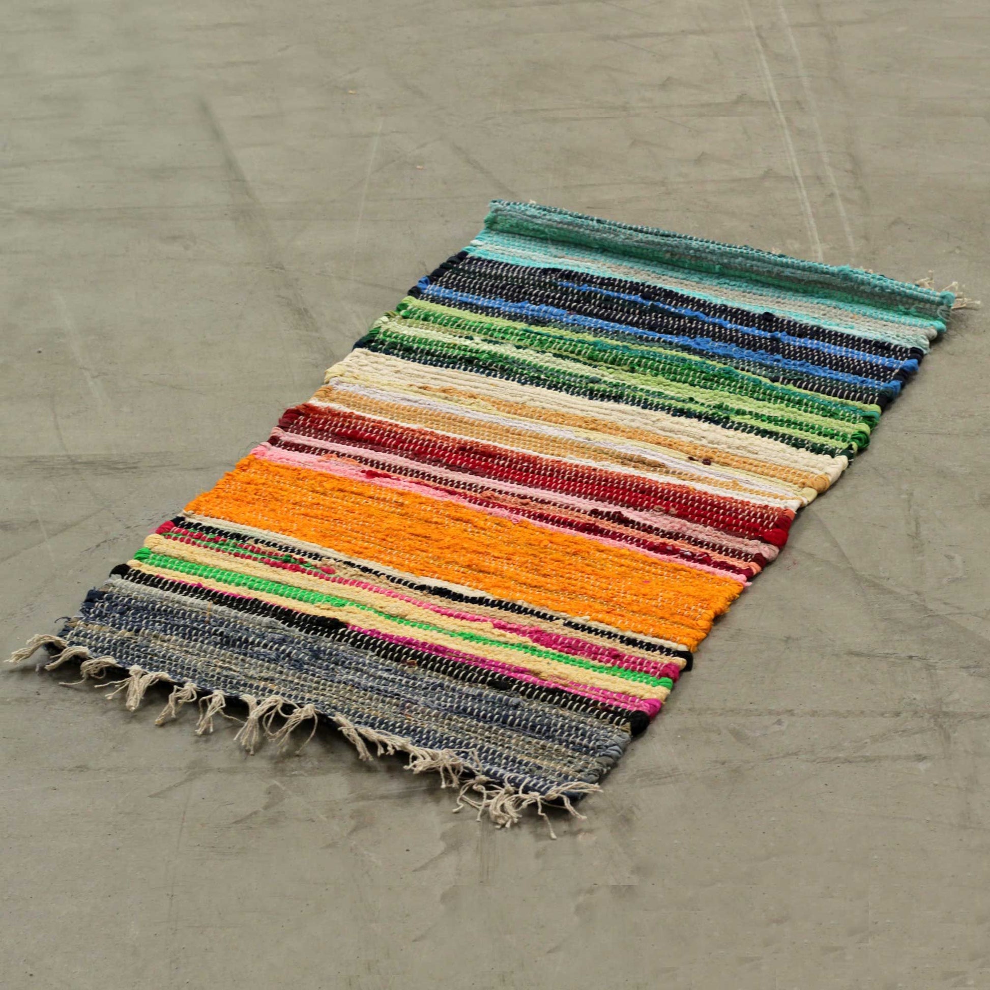 Handwoven small rag rug featuring vibrant rainbow stripes and a textured premium finish.