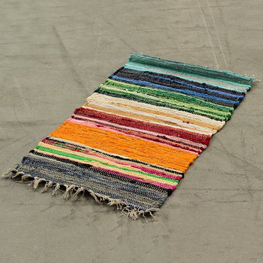 Handwoven small rag rug featuring vibrant rainbow stripes and a textured premium finish.
