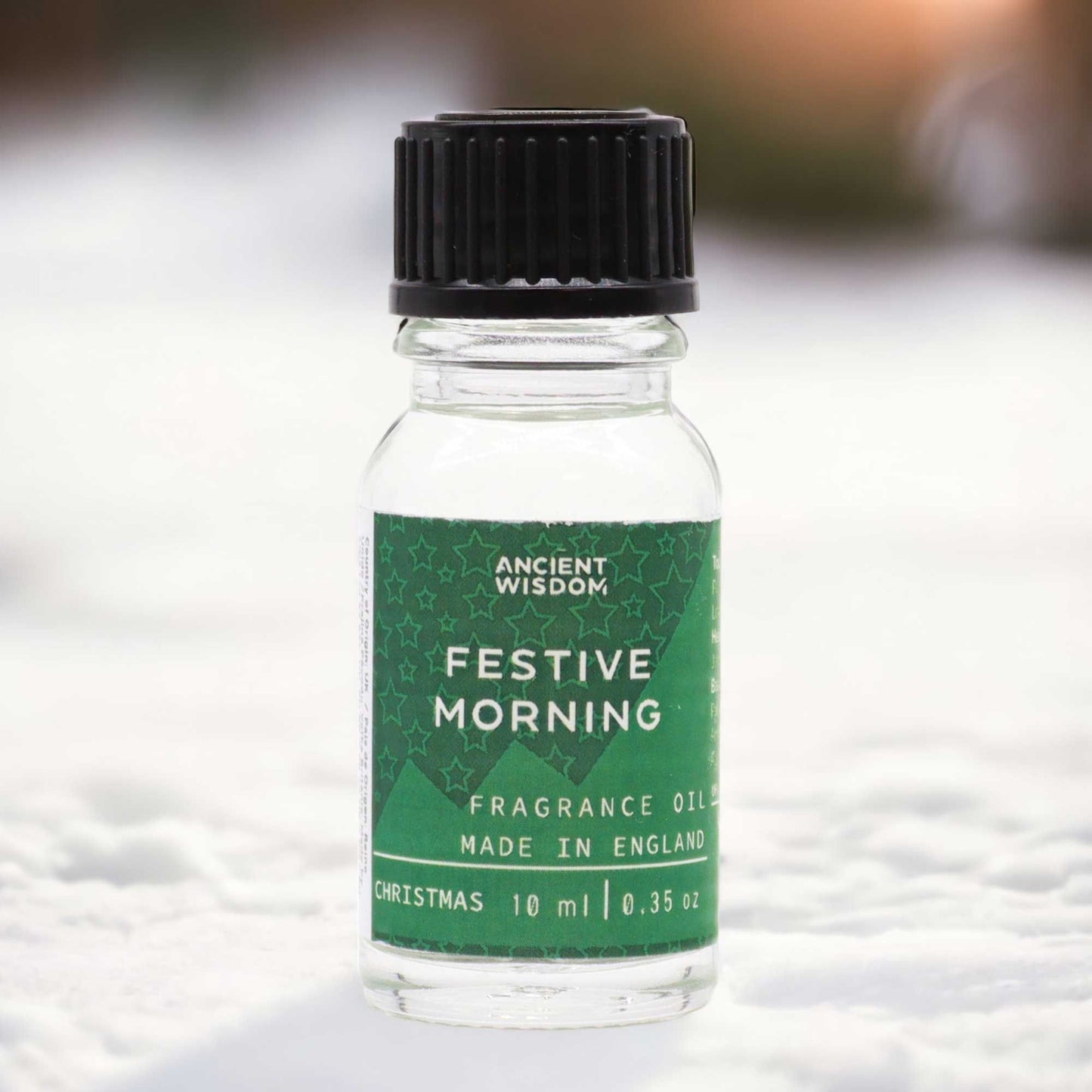 Small amber glass bottle of Festive Morning fragrance oil with a simple white label and black dropper cap.