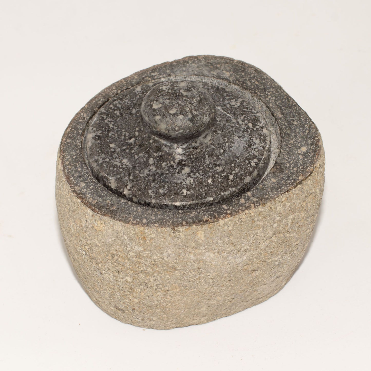 Small hand-carved natural riverstone pot with a smooth organic texture and soft grey earthy tones.