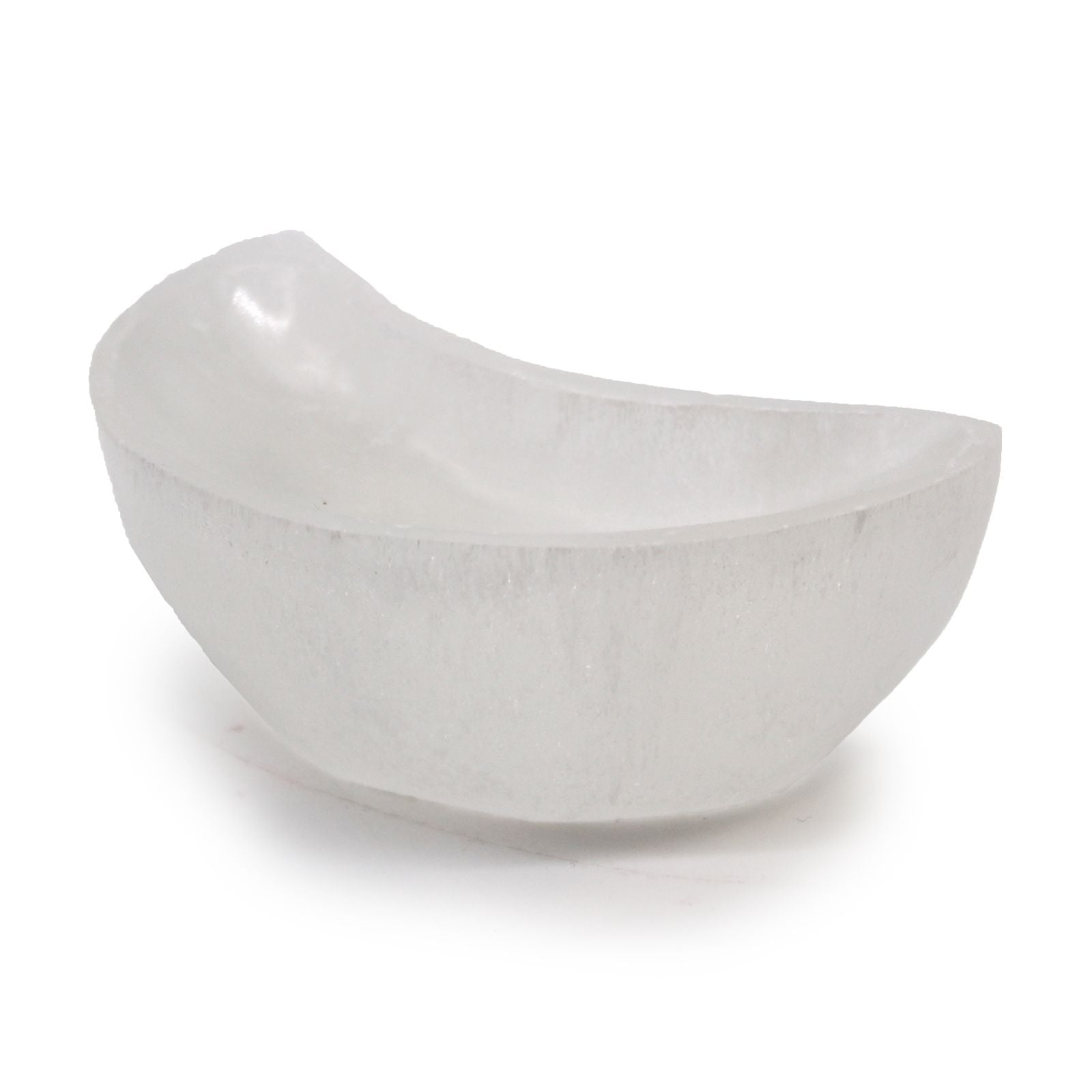 White translucent hand-carved selenite bowl in a crescent moon shape on a plain background.