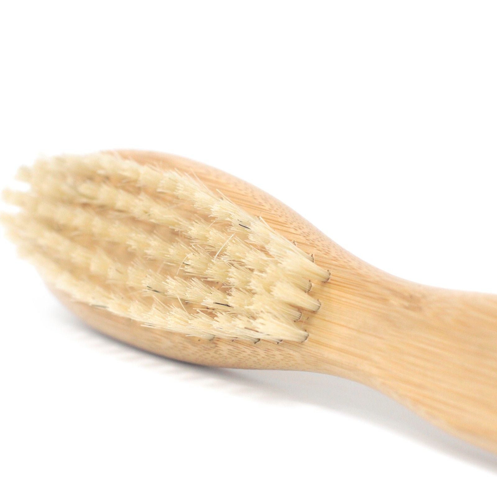 Close-up of a high-quality beard brush with natural stiff bristles and a smooth wooden handle.