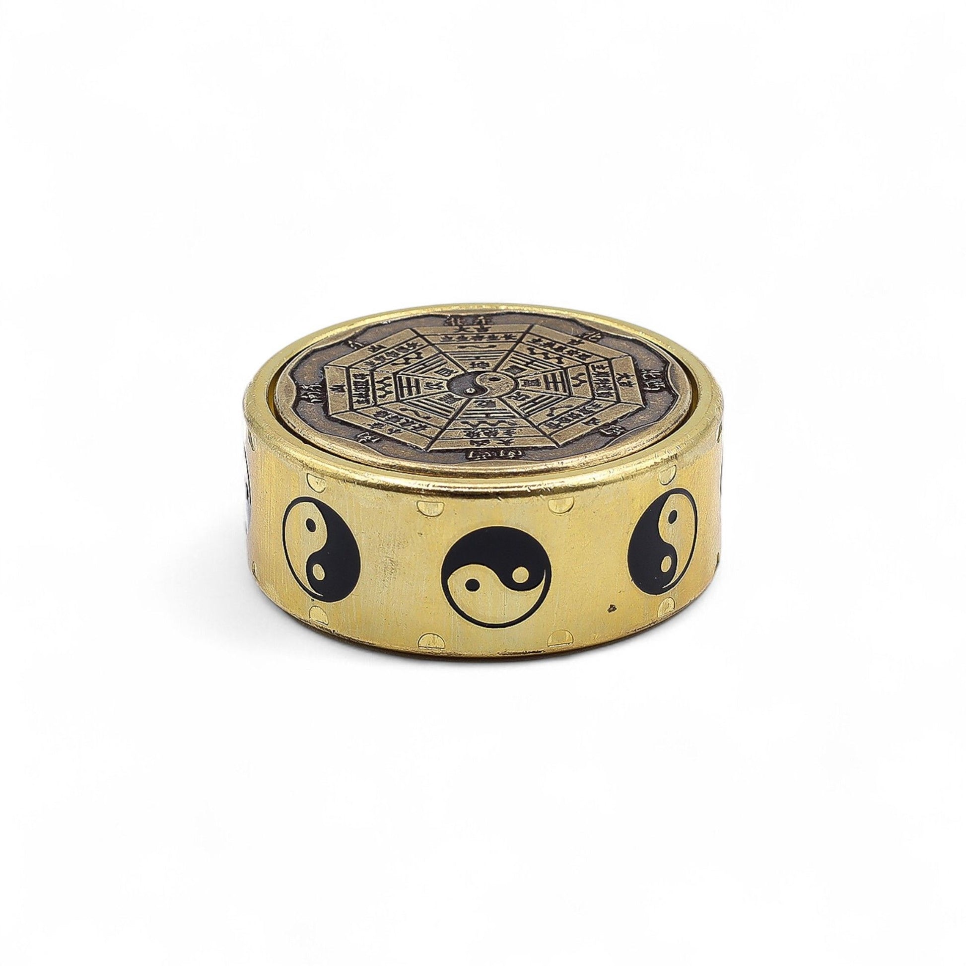 Round metallic spinner disc featuring the Yin-Yang symbol and traditional Bagua trigrams on a dark background.