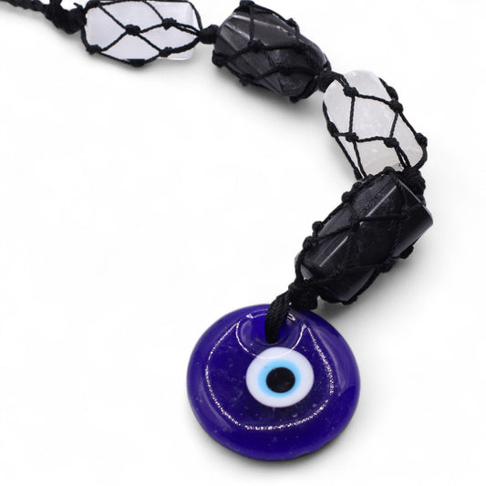 Hanging spiritual ornament featuring raw black tourmaline and white selenite stones with a blue glass evil eye charm.
