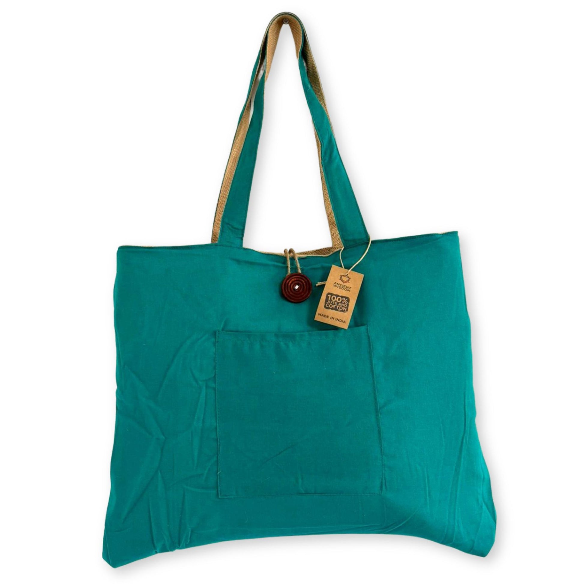 Large teal and natural jute reversible tote bag with sturdy cotton handles in a minimalist setting.