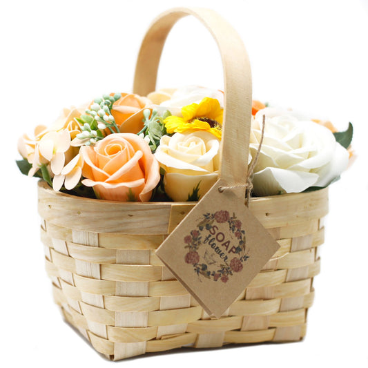 Large orange soap flower arrangement featuring roses, hyacinths and a sunflower in a rustic wicker basket.