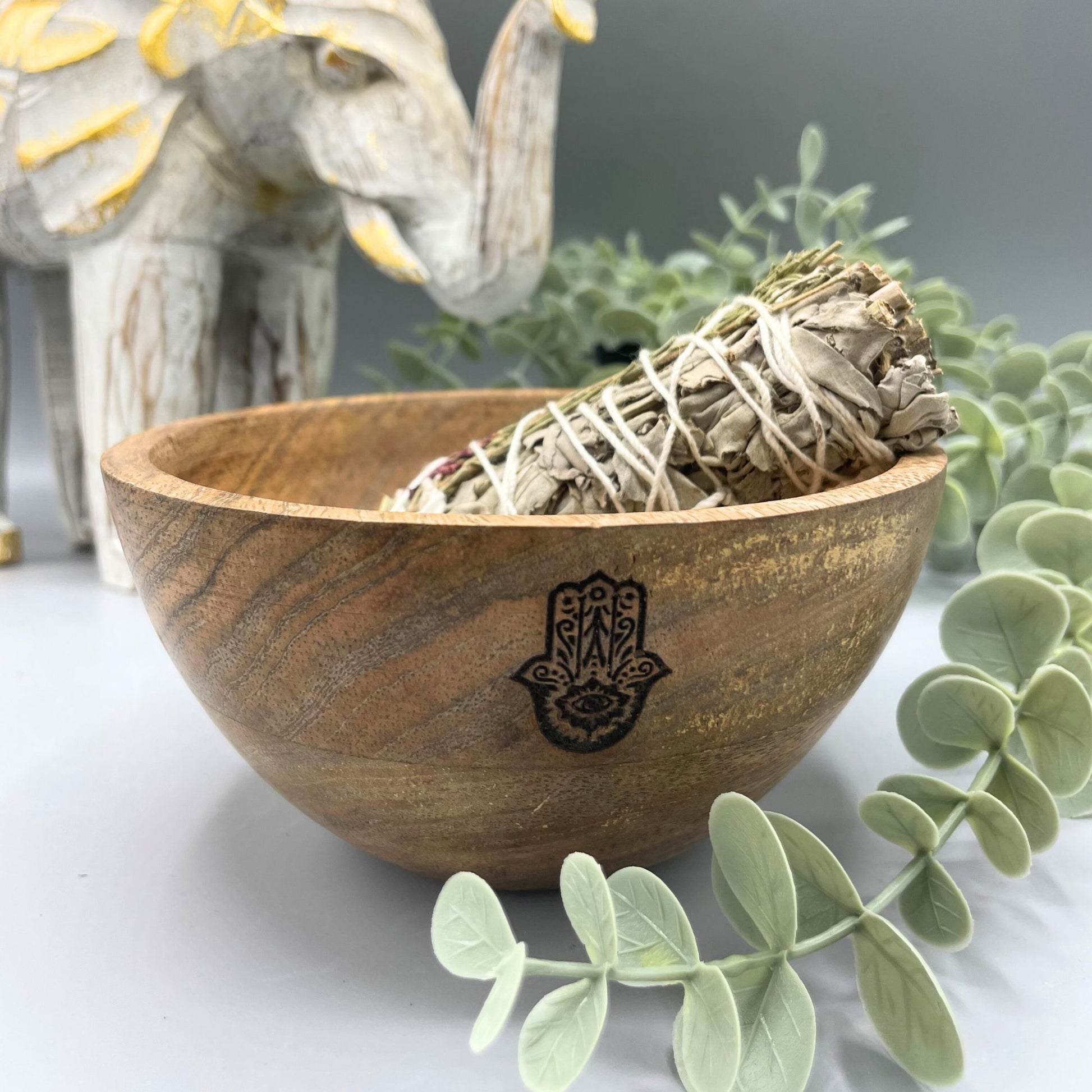 Handcrafted wooden ritual bowl featuring an engraved Hamsa hand symbol in a natural wood finish.