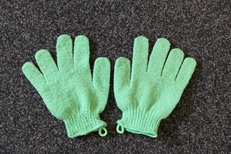 Pair of textured green exfoliating gloves designed for spa-quality body treatments and skin renewal.