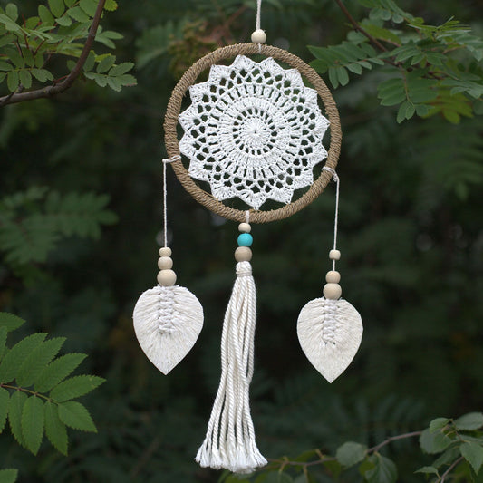 Handmade vegan dream catcher made from natural materials with a complex web design and hanging wooden elements.