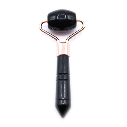 Miniature black obsidian gemstone face roller with a smooth polished finish and silver-toned metal frame.