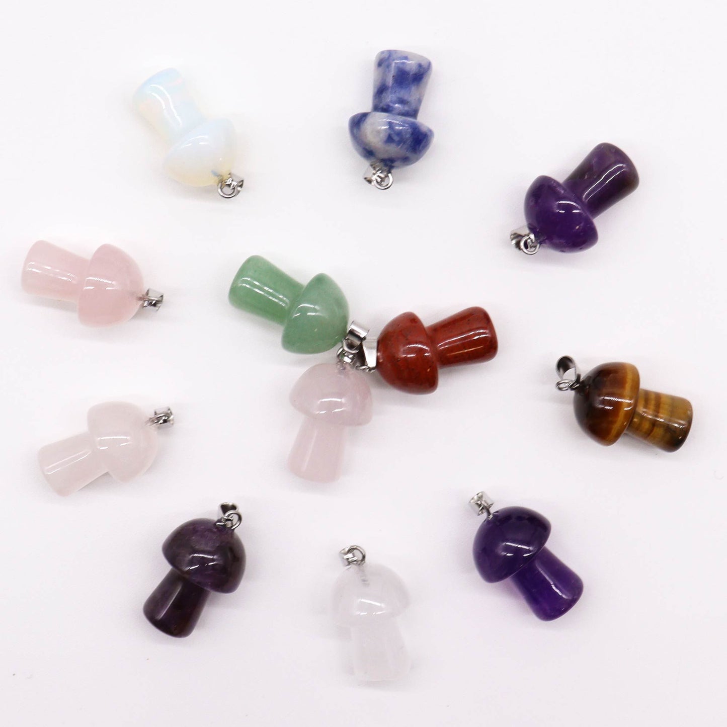 Twelve assorted colourful gemstone pendants carved into small mushroom shapes with silver-toned metal bails.