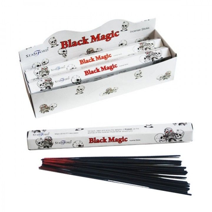 Hexagonal box of premium black magic incense sticks on a dark wooden surface with soft ambient lighting.